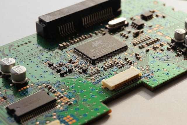 A green computer board with many small parts and chips on it.